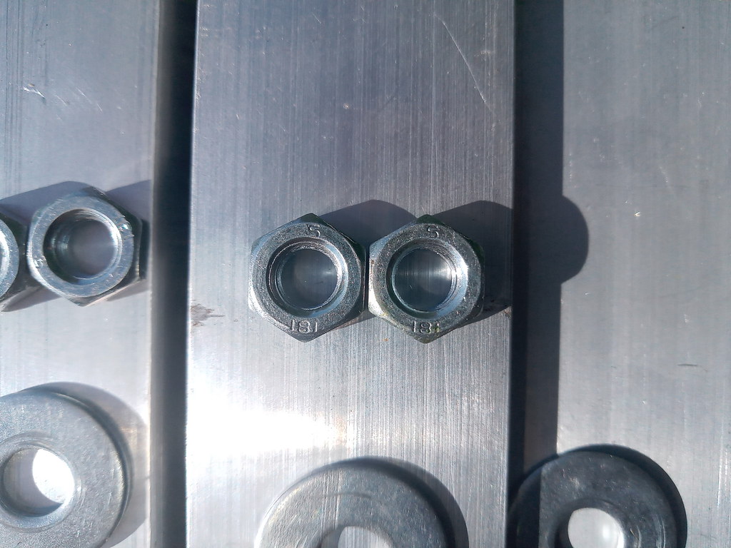 Metal washers and nuts on a steel surface